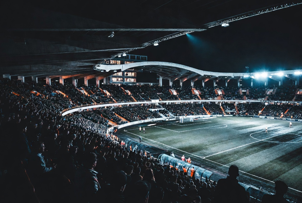 Arsenal vs Liverpool — night stadium full of fans with orange accents