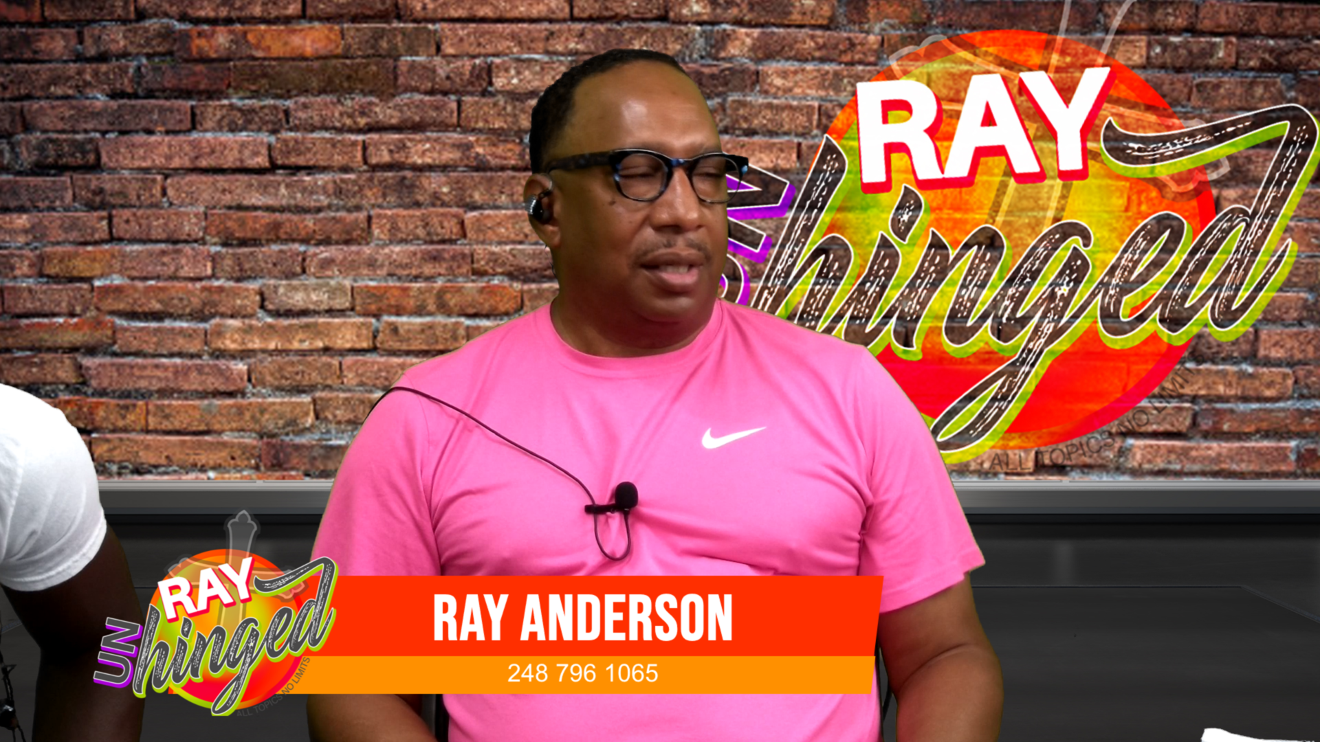 Broadcast-grade production studio — Ray Unhinged show produced by Blazing Blaine, featuring professional lower-thirds, branded backdrop, and lavalier mic setup