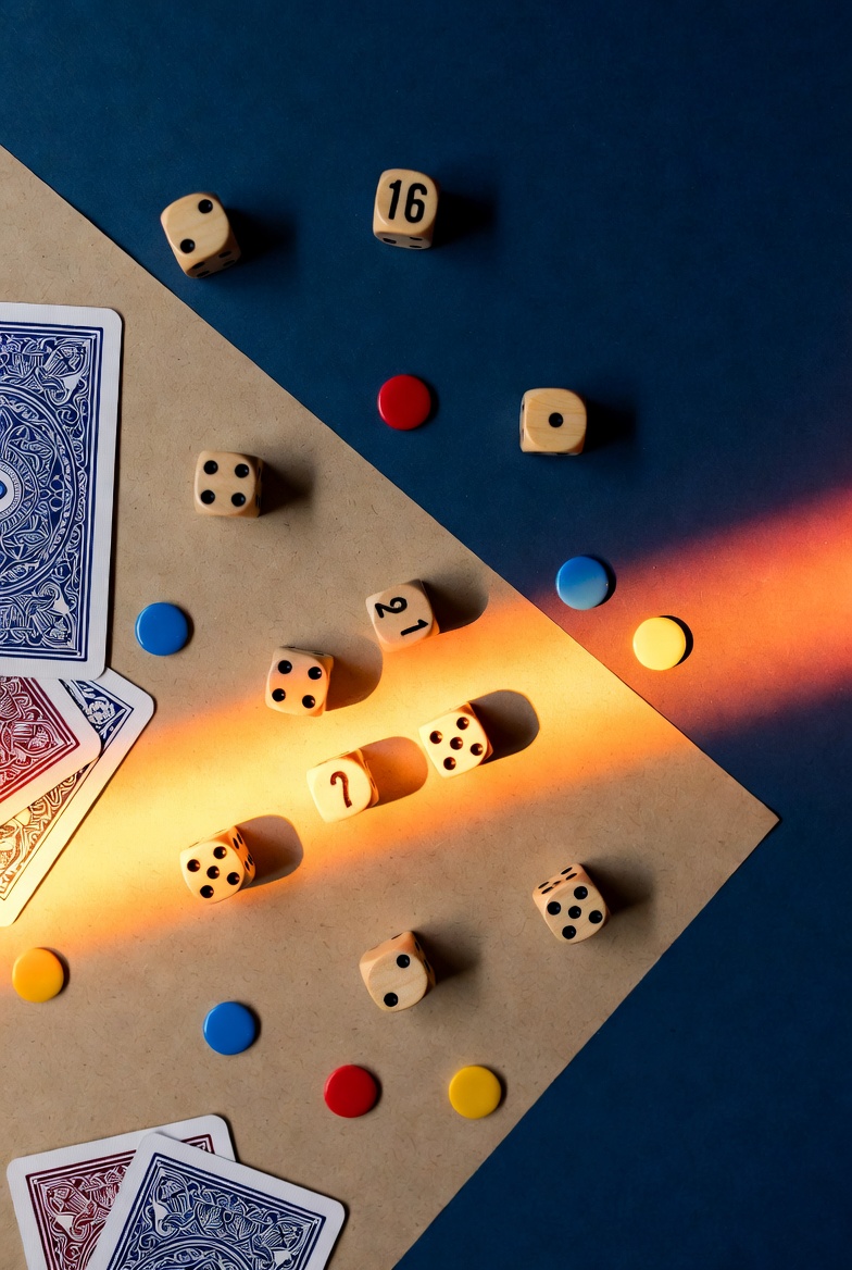 Dice, playing cards and colorful chips scattered on a surface — board game night atmosphere